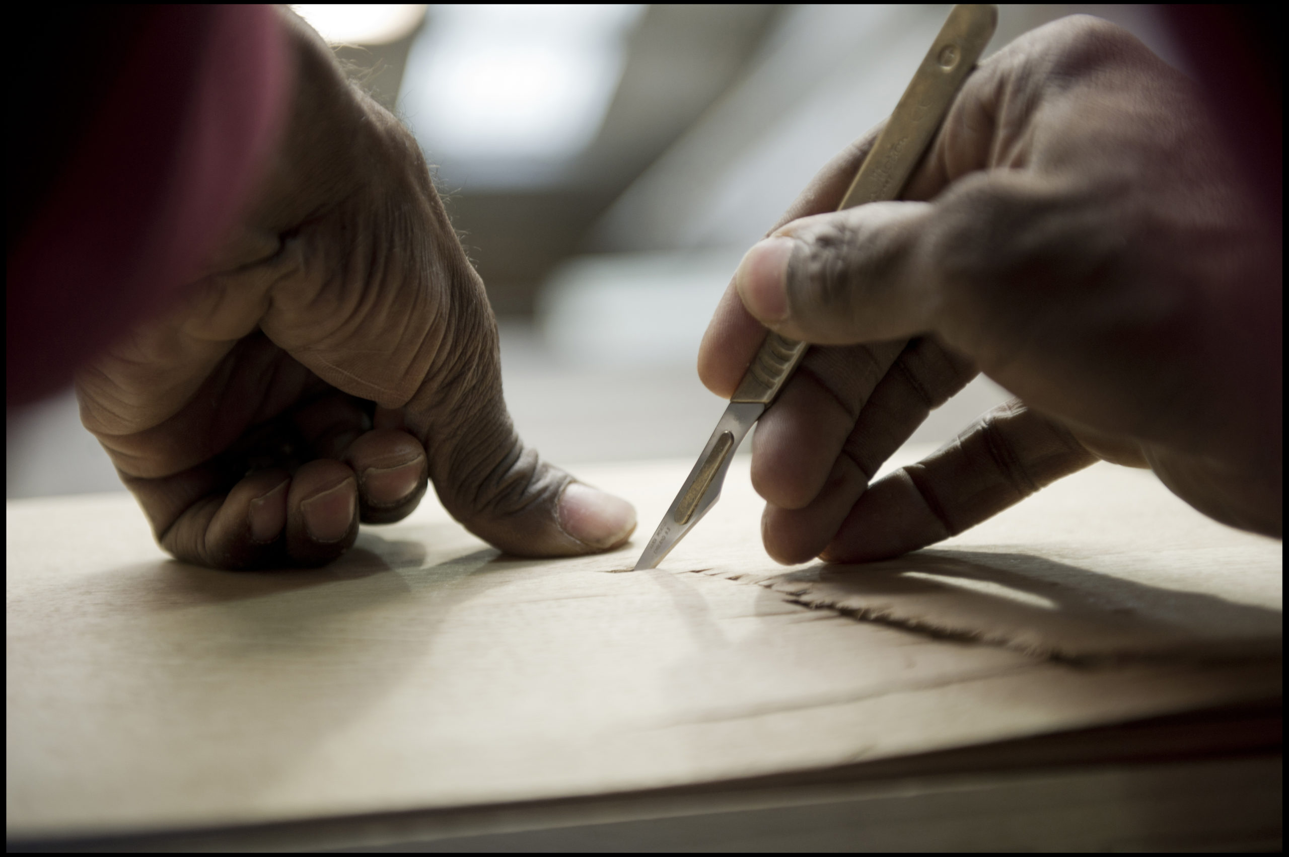 Picture of hands on wood and drawing a line on the wood